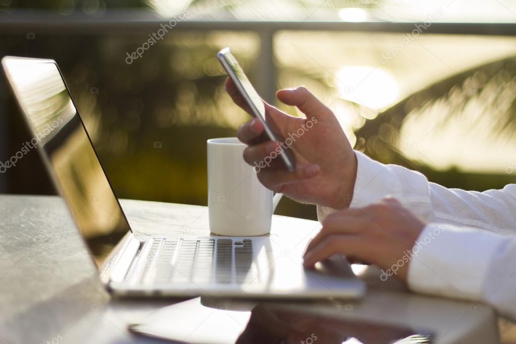 Businessman with cell phone and laptop