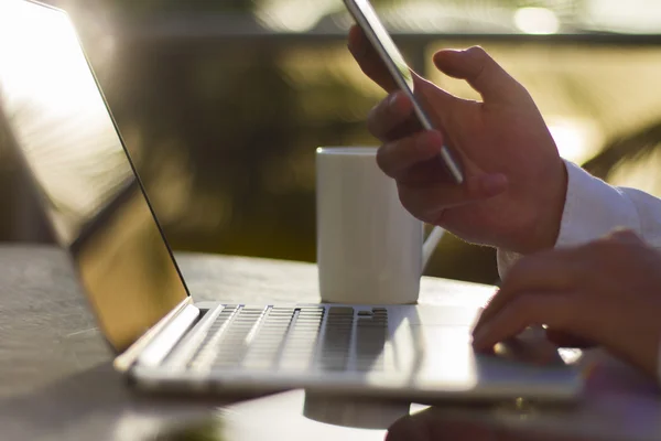 Uomo d'affari con cellulare e laptop — Foto Stock