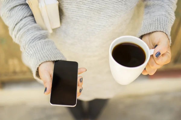 Cep telefonu Kupası ve kitaplar ile kız — Stok fotoğraf