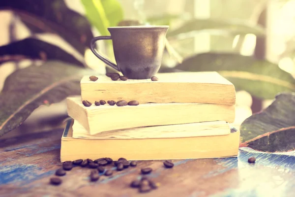 Bücher, Kaffeebohnen und eine Tasse im Freien — Stockfoto