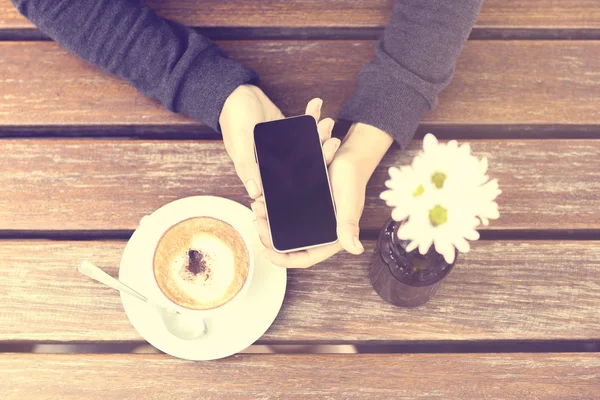 Dziewczyna z telefonów komórkowych i filiżankę kawy — Zdjęcie stockowe