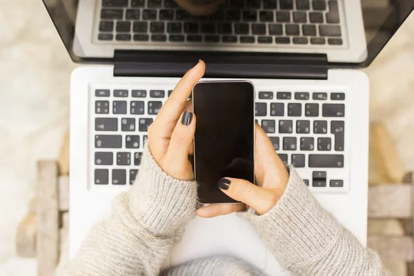 Menina com telefone celular e laptop — Fotografia de Stock