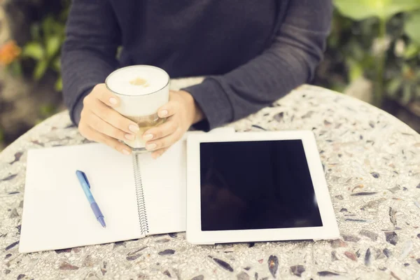 Девушка с цифровым планшетом, чашкой кофе и ноутбуком — стоковое фото