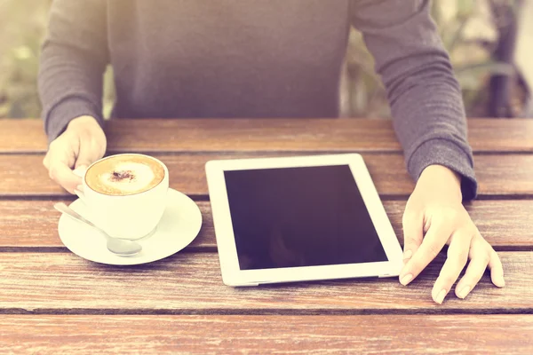 Fille avec tablette numérique et tasse de café au lever du soleil — Photo