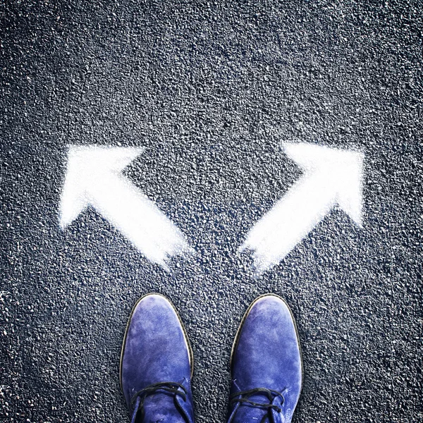 Mannen schoenen en twee pijlen in verschillende richtingen — Stockfoto