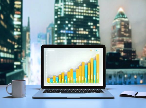 Laptop med business diagram i office på kvällen — Stockfoto