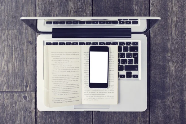 Lege smartphone op open boek en laptop op een vloer, vintage pho — Stockfoto