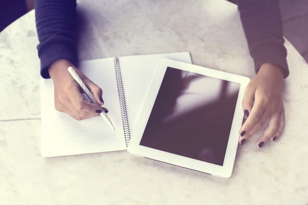 Fille écrit dans un carnet et de travailler avec une tablette numérique — Photo