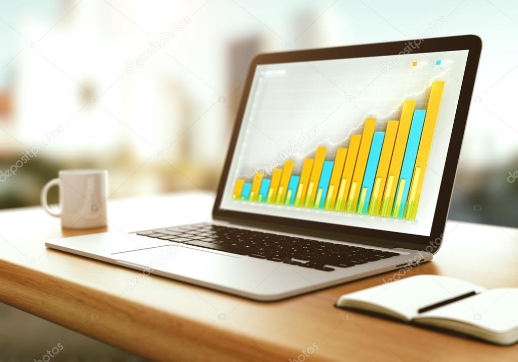 Laptop with business graph on a wooden table at sunset