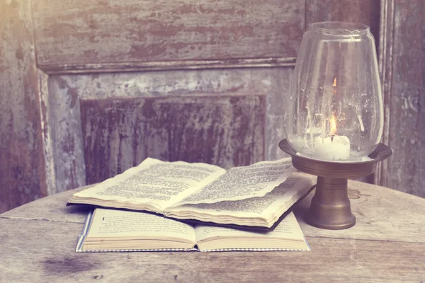 Open books on the old wooden table near the lamp — Stock Photo, Image