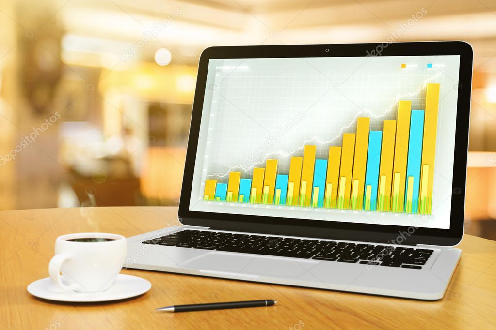 Laptop with business chart, pen and cup of coffee on a wooden ta