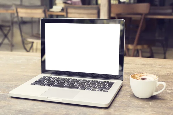 Laptop e xícara de café na mesa — Fotografia de Stock