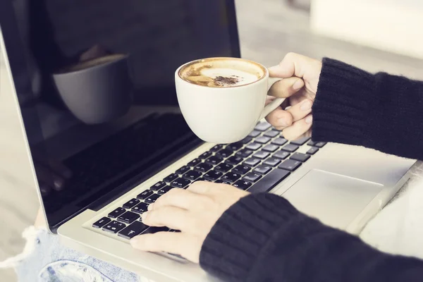 Menina com xícara de cappuccino e laptop — Fotografia de Stock