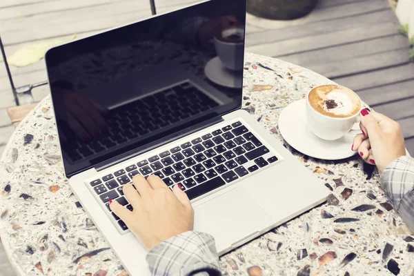 Menina com laptop e cappuccino — Fotografia de Stock