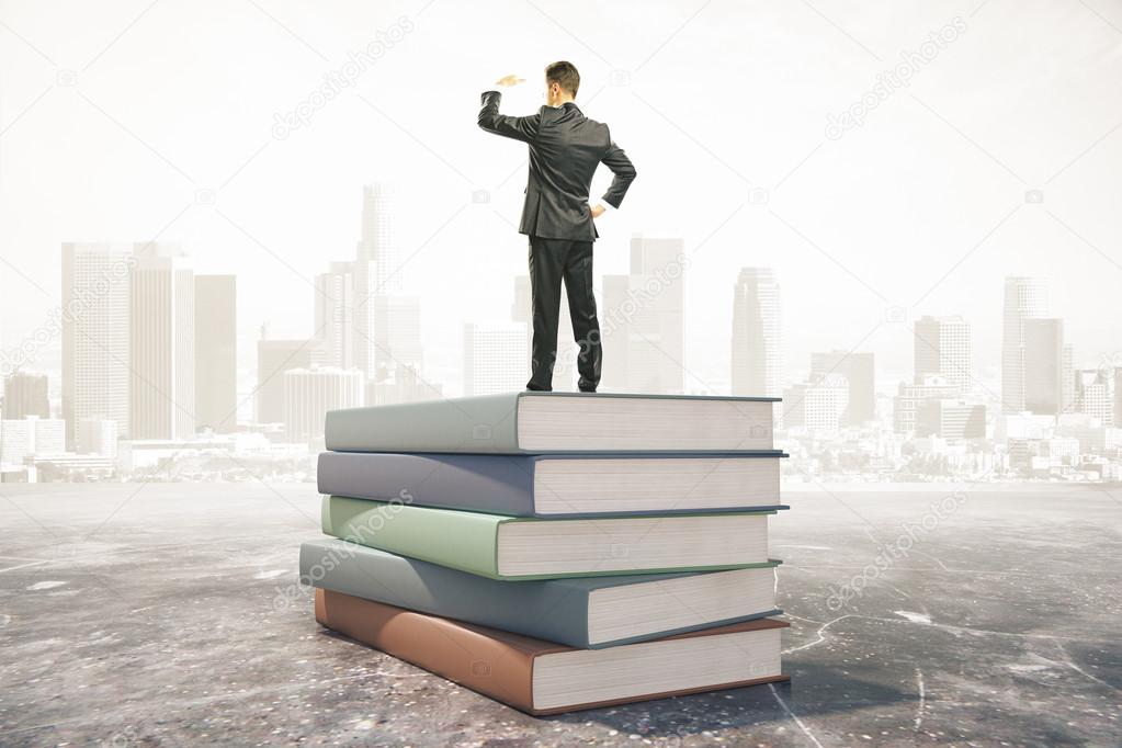 Businessman standing on pile of books