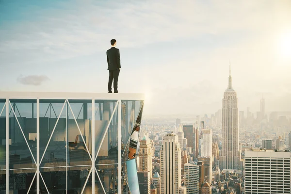 Empresario en la parte superior del rascacielos mirando a la ciudad — Foto de Stock