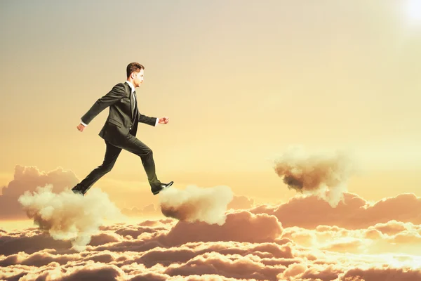 Бизнесмен ходит по облакам в концепции неба — стоковое фото