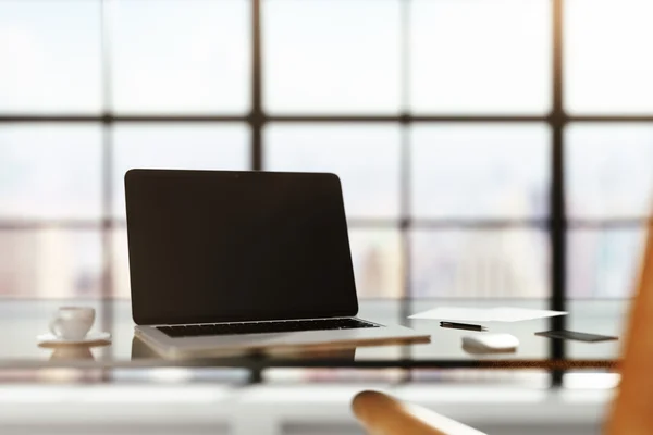 Laptop em branco na mesa vítrea no quarto ensolarado, simular — Fotografia de Stock