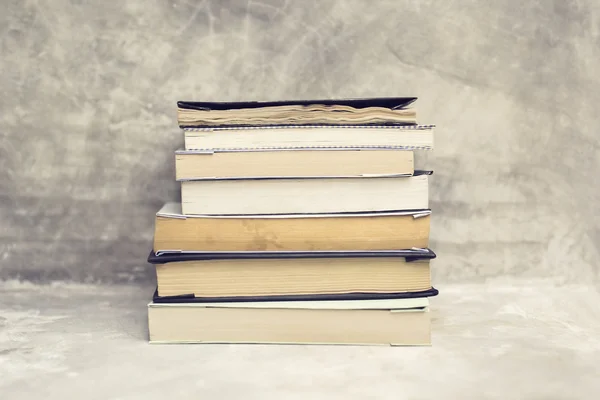 Pile of old books on concrete shelf — Stock Photo, Image