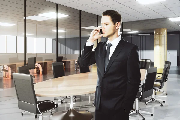 Empresário falando ao telefone na moderna sala de conferências — Fotografia de Stock