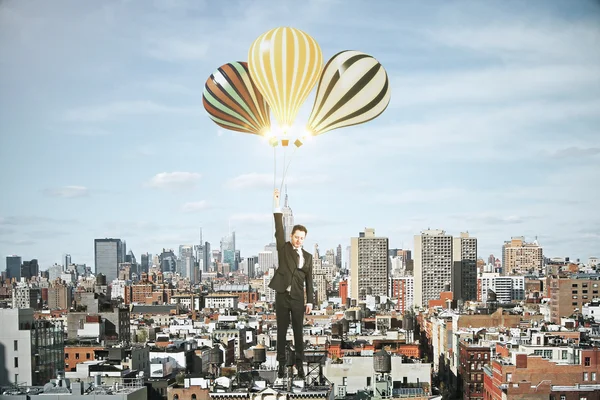 Homme d'affaires avec des ballons au-dessus du concept de ville de mégapole — Photo