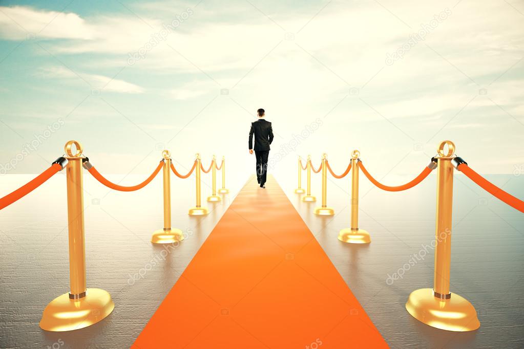 Businessman walking on red carpet to the sunny future concept