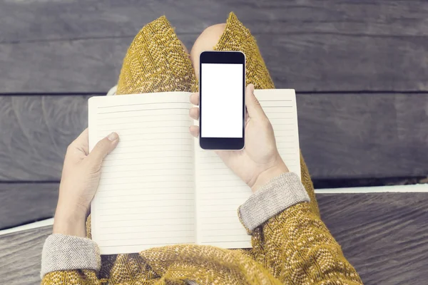 Flicka med mobiltelefon skärm och dagbok — Stockfoto