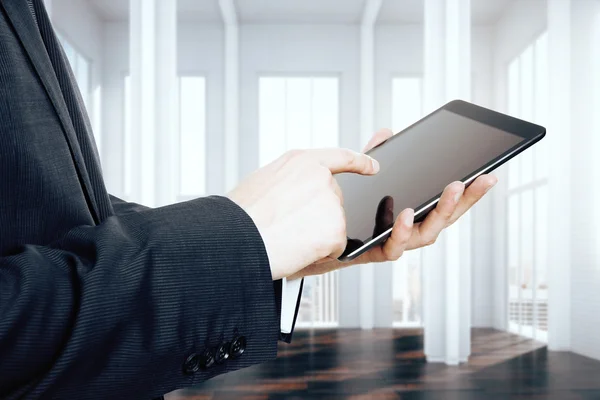 Бизнесмен, использующий цифровой планшет в пустой лофт-комнате — стоковое фото