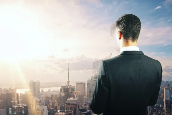 Businessman looking at sunrise from the top of building — Stock Photo, Image