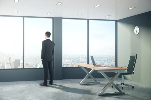 Empresário está olhando pela janela em estilo loft moderno offic — Fotografia de Stock