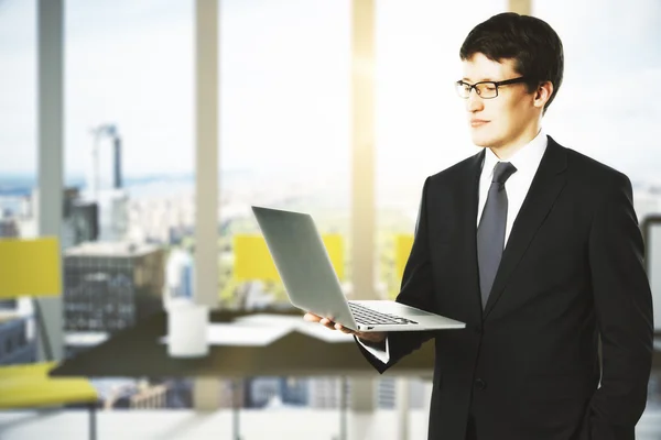Homem de negócios com laptop no escritório moderno — Fotografia de Stock