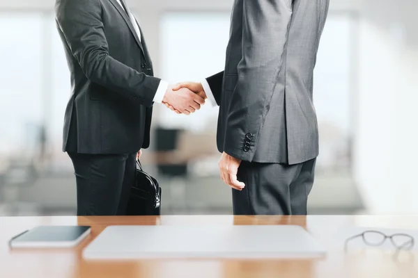 Два бізнесмени тремтять руками в офісі — стокове фото
