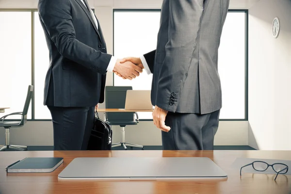 Два бізнесмена тремтять руками в сучасному офісі — стокове фото