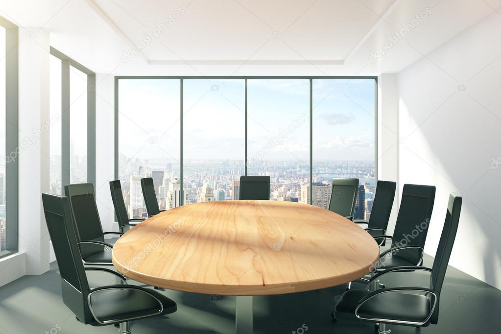 Sunny conference room with oval table, chairs and city view