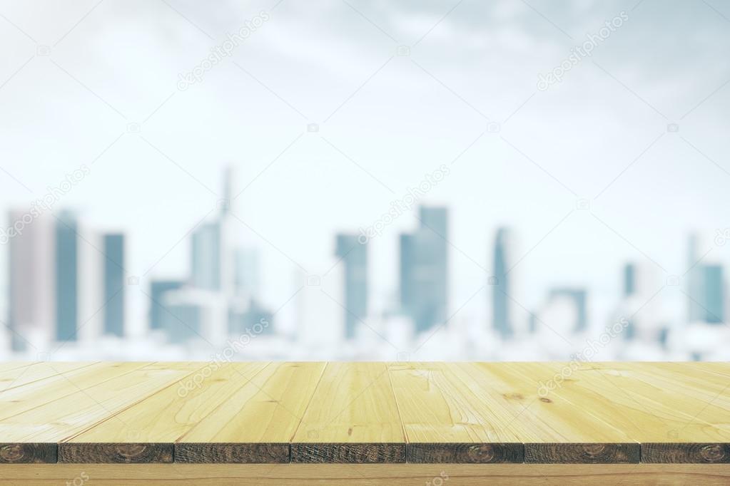 Empty wooden table with a blurred background of the city