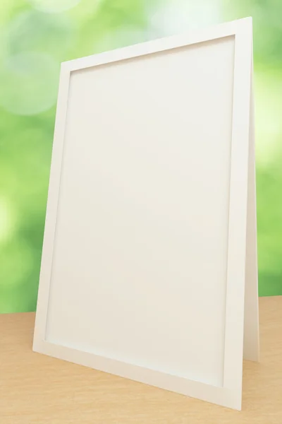 Blank white picture frame on wooden table, mock up — Stock Photo, Image