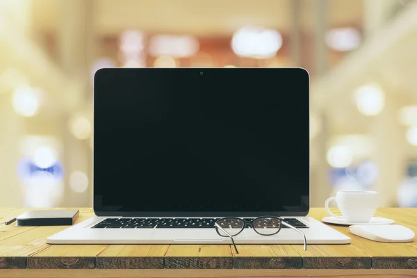 Üres fekete laptop képernyő bögre kávét és szemüveg fa — Stock Fotó
