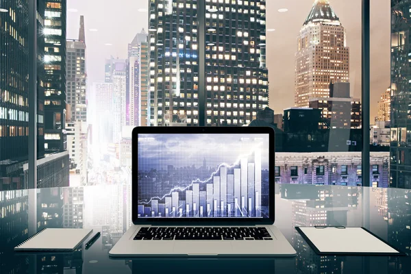Notebook s obchodní graf na obrazovce na skleněný stůl v z — Stock fotografie