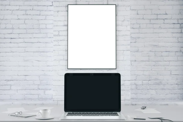 Leeg afbeeldingsframe op witte bakstenen muur en lege zwarte laptop s — Stockfoto