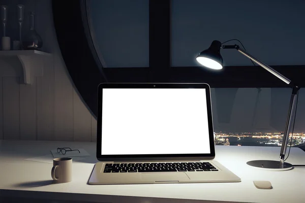 Prázdné bílé laptop obrazovky na stole a lampy v kanceláři wi — Stock fotografie