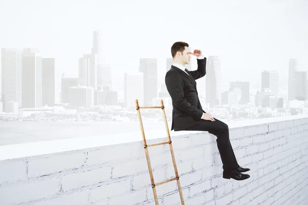 Empresário sentado na parede de tijolo branco e escada de madeira em cit — Fotografia de Stock