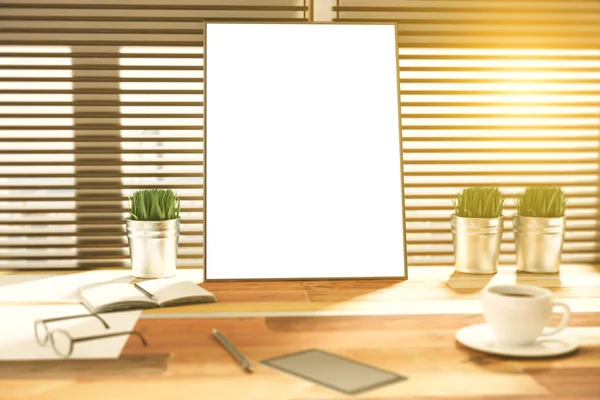 Blank picture frame on a wooden desk at sunset — Stock Photo, Image