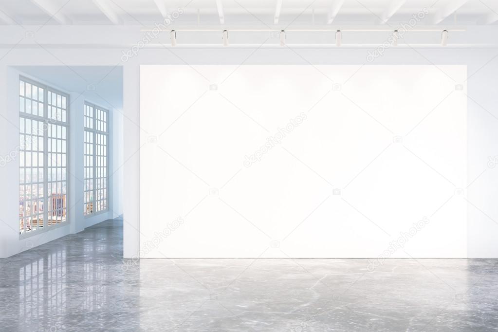 Blank white poster on white wall in empty loft room with concret