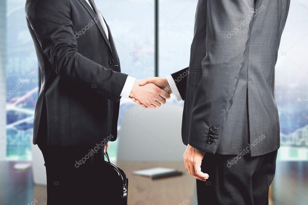 Two businessman shaking hands in office