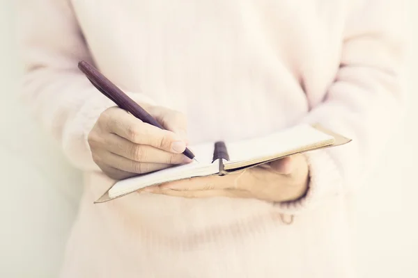 She writes something in notebook closeup — Stock Photo, Image