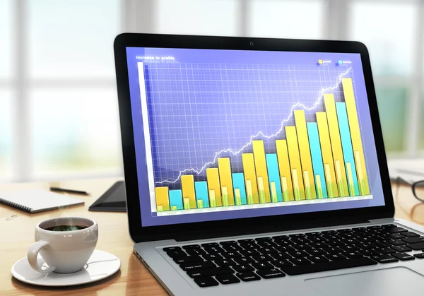 木製タブにコーヒー カップとノート パソコンの画面上のビジネス グラフ — ストック写真