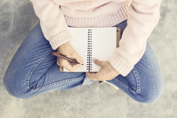 Flicka med Tom dagbok och penna på betonggolv — Stockfoto