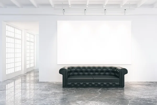 Poster gol pe perete în camera mansardă cu canapea din piele neagră — Fotografie, imagine de stoc