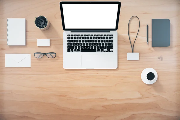 Blank laptop screen with office accessories on wooden table, moc