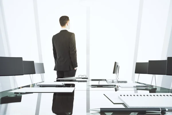 Businessman looking out the window in modern conference room wit — Stock Photo, Image
